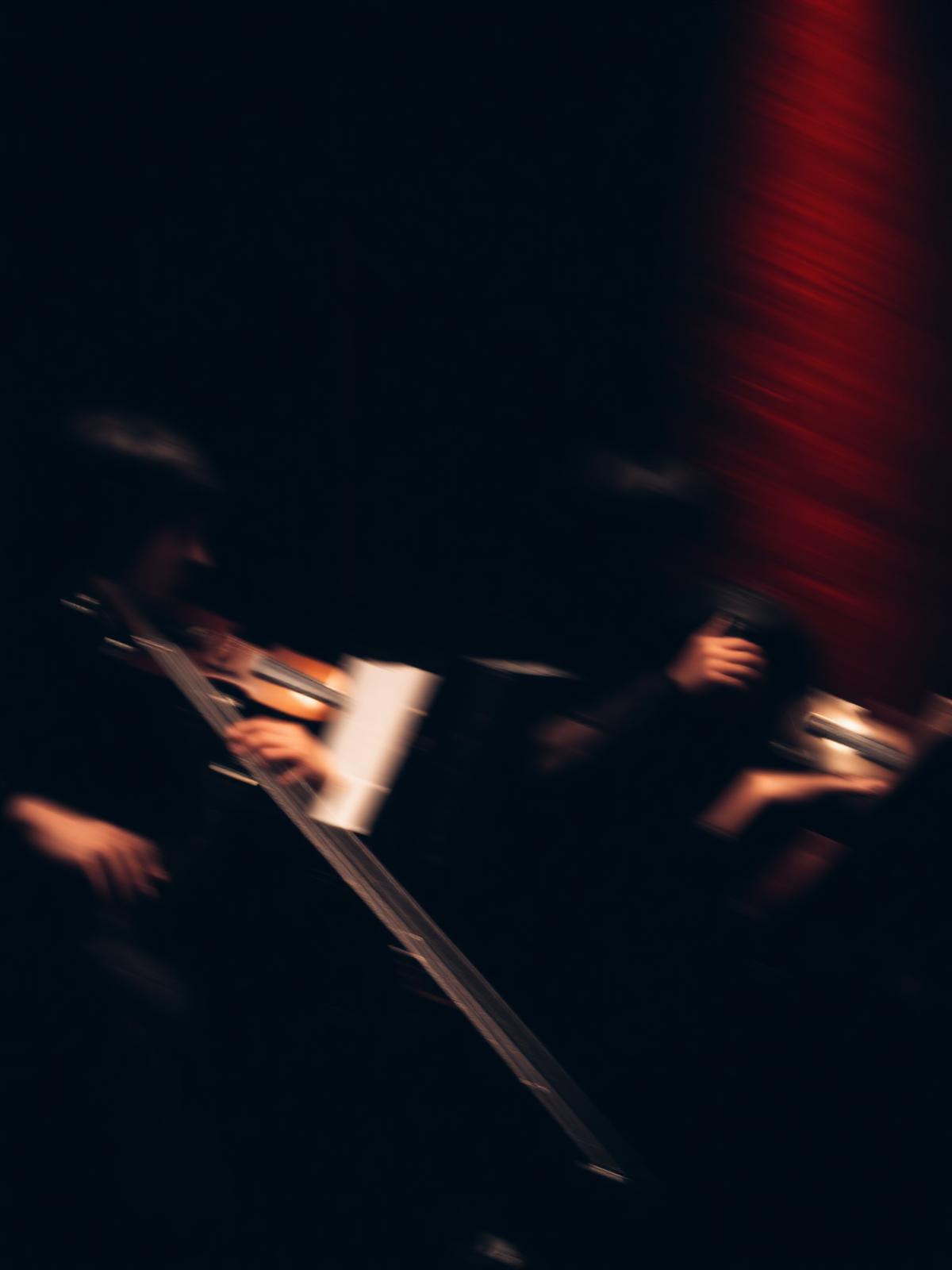 Abstract blur of a string quartet performing in deep shadows